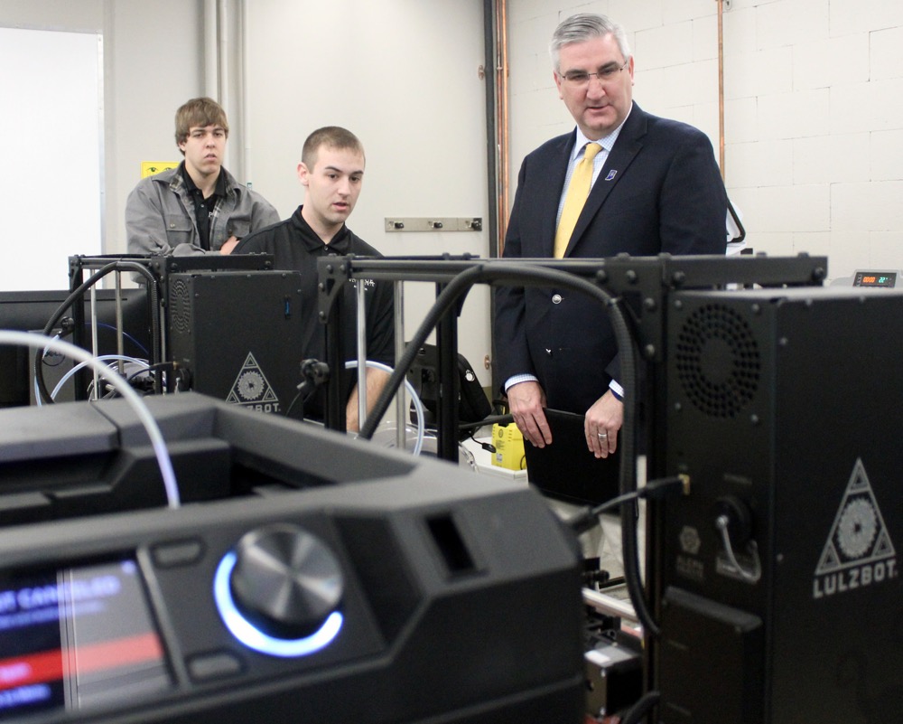 Dylan Alkire and Lucas Gibbons, Purdue Polytechnic engineering technology students, share with Gov. Holcomb how they use 3-D printing technology for design, prototyping, materials and processes courses at the Anderson location. (photo courtesy Office of Gov. Holcomb)