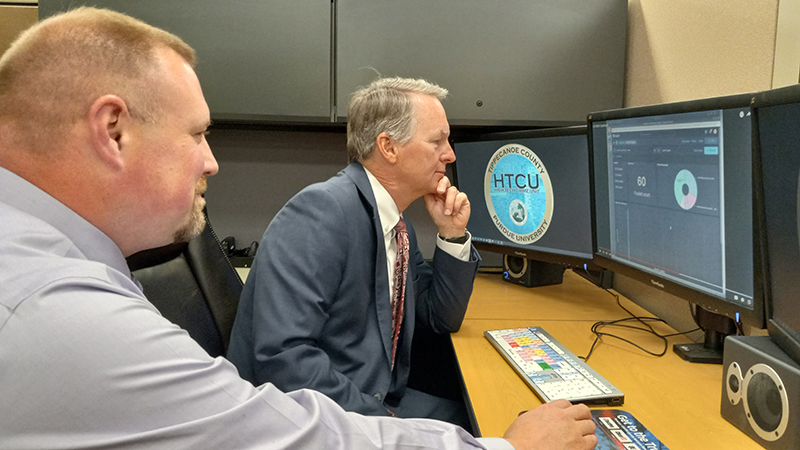 Sean Leshney (left), director of digital forensics investigations at the Tippecanoe County HTCU, and Patrick Harrington, Tippecanoe County prosecutor, view an analysis of digital evidence created by the FileTSAR+ forensic tool. (Purdue Research Foundation/Steve Martin)