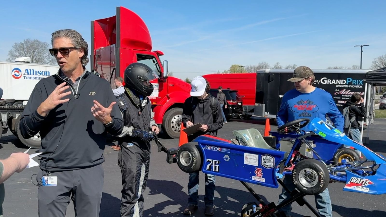Ryan Milburn, product engineering vice president at Allison Transmission, discusses the similarities between electric karts and electric semi-trucks as a student team prepares their kart for a track run. (Purdue University photo/John O'Malley)