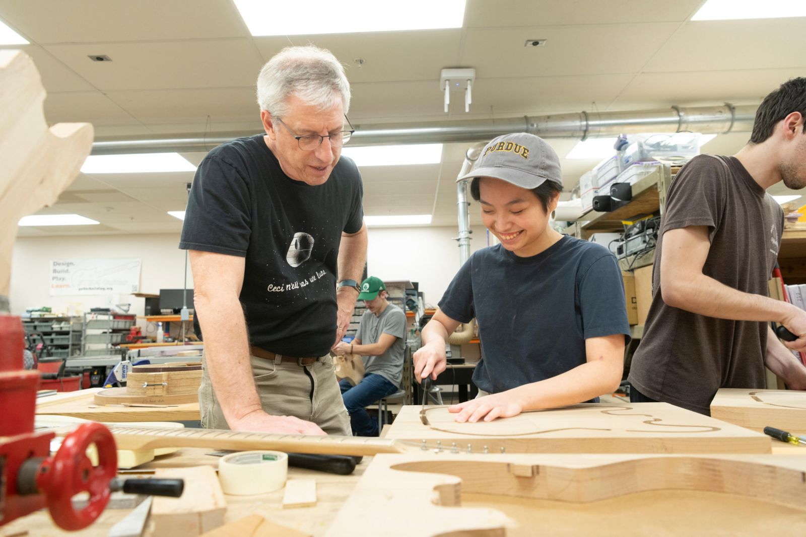 Professor Mark French works with a student on a guitar body in Purdue Polytechnic's popular "guitar lab" course.